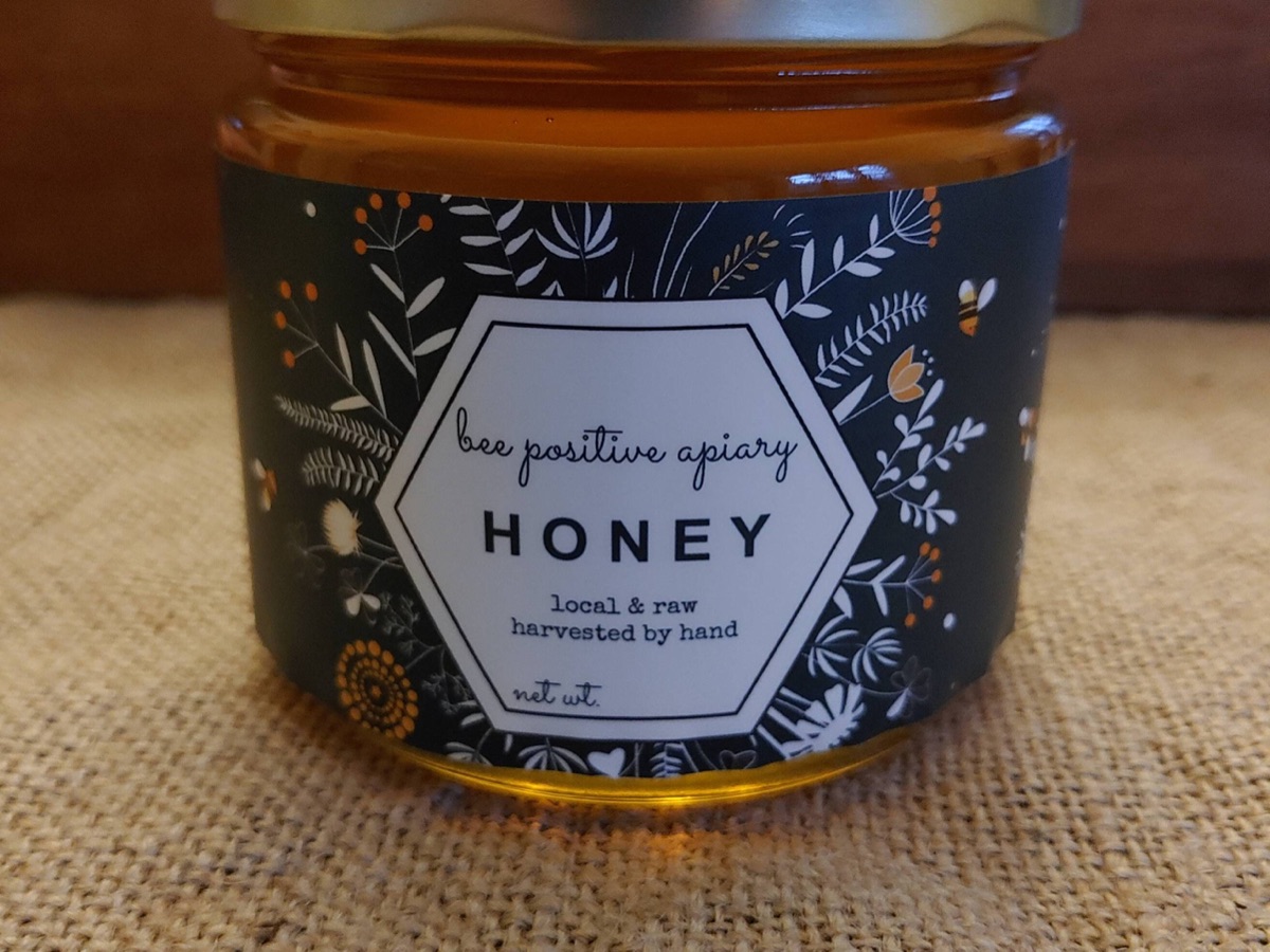 A 1 lb jar of Bee Positive Apiary honey